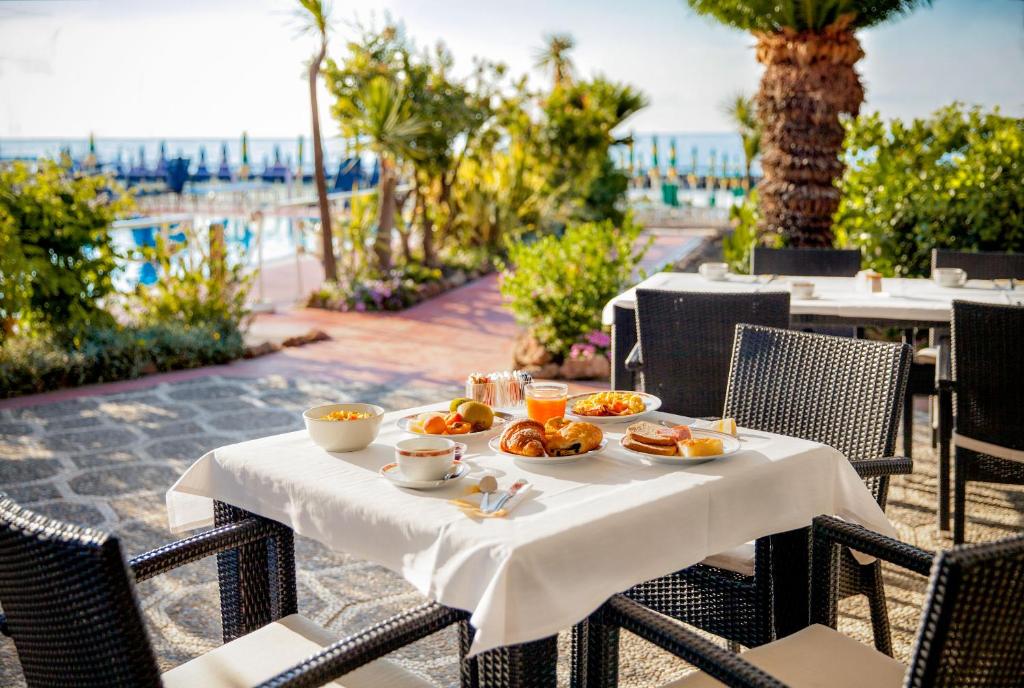 - une table avec des assiettes de nourriture au-dessus d'une terrasse dans l'établissement Hotel Gabriella, à Diano Marina