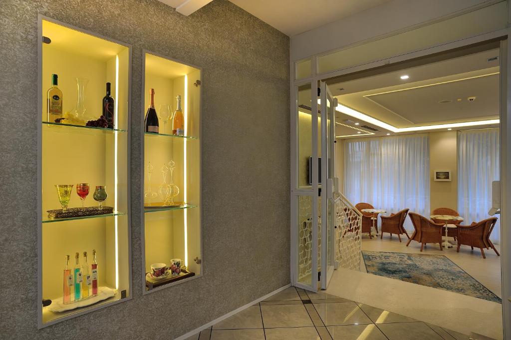 un couloir avec des étagères en verre et des bouteilles de vin dans l'établissement Hotel Principe, à Cattolica