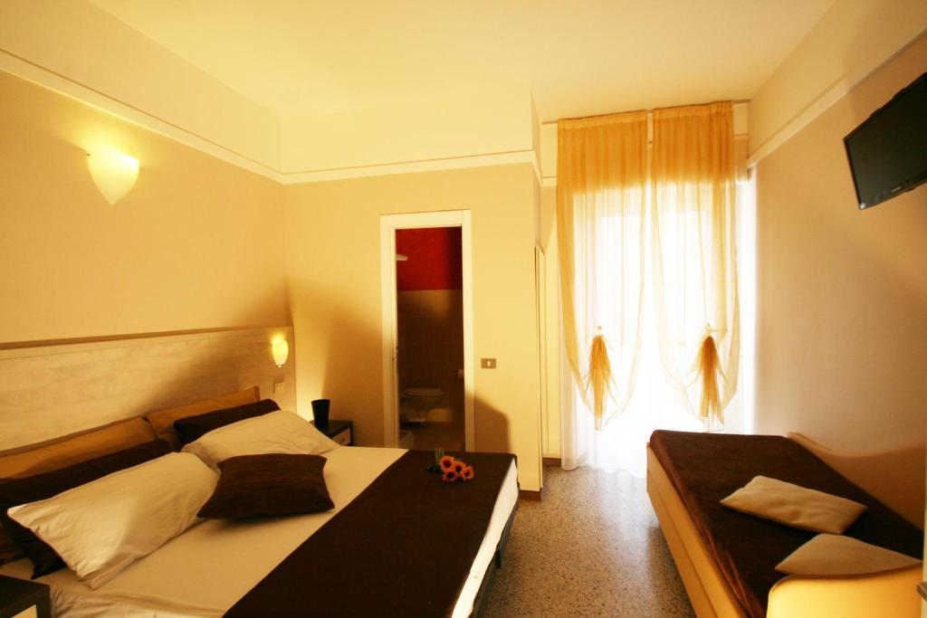 une chambre d'hôtel avec deux lits et une fenêtre dans l'établissement Hotel London, à Cattolica