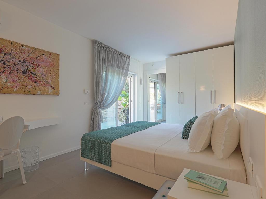 une chambre avec un lit, un bureau et une fenêtre dans l'établissement Il Giardino degli Dei, à San Leone