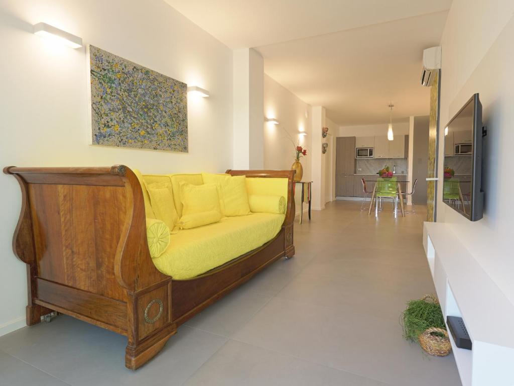 - un canapé avec des oreillers jaunes dans le salon dans l'établissement Il Giardino degli Dei, à San Leone