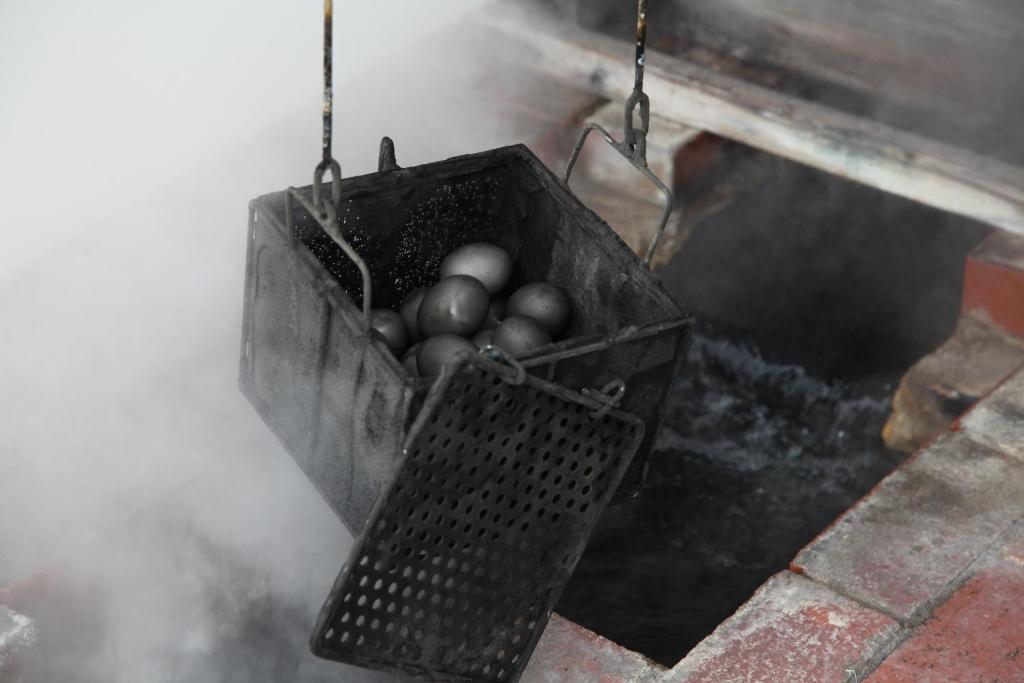 un panier rempli d'œufs suspendus à un fumeur dans l'établissement Jyokiya, à Unzen