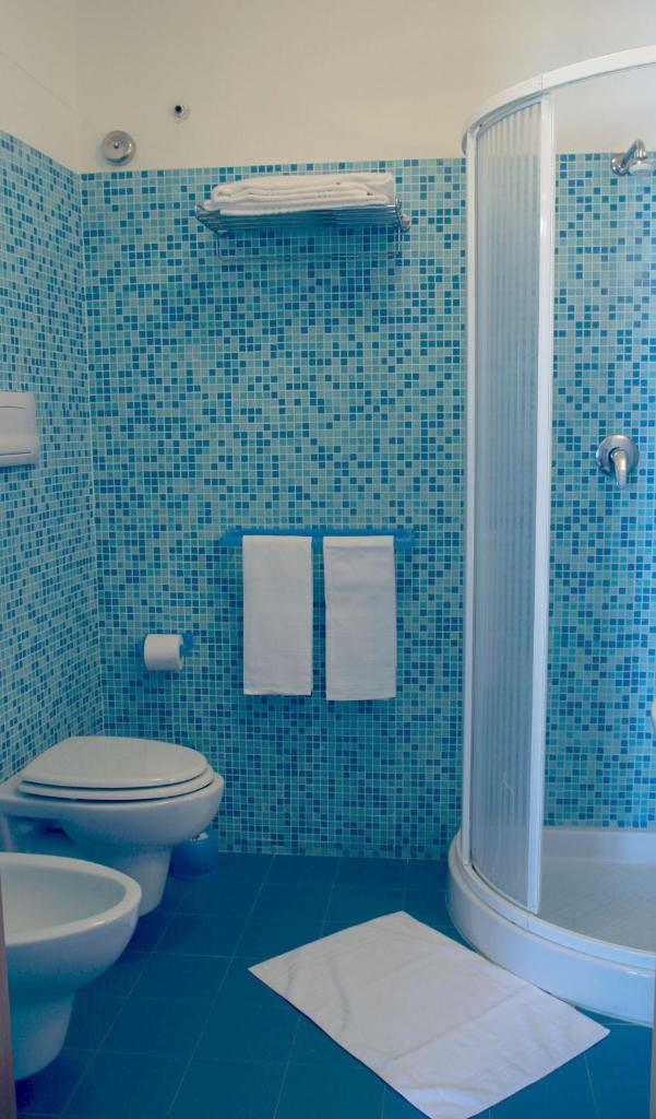La salle de bains est pourvue de carrelage bleu, de toilettes et d'une douche. dans l'établissement Il Gabbiano, à Stalettì 83 autres photos