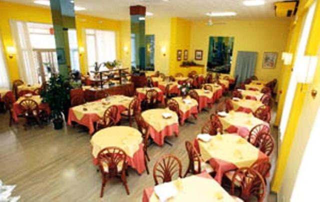 une salle à manger remplie de tables et de chaises dans l'établissement Hotel Reno, à Lido di Jesolo