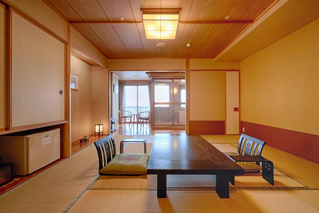une salle à manger avec une table et des chaises en bois dans l'établissement Yunohama Hotel, à Hakodate