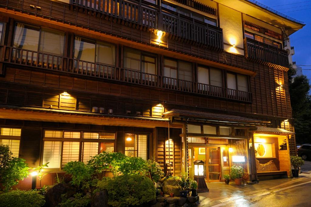 un grand bâtiment avec des lumières sur son côté dans l'établissement Irorinoyado Ashina, à Aizuwakamatsu