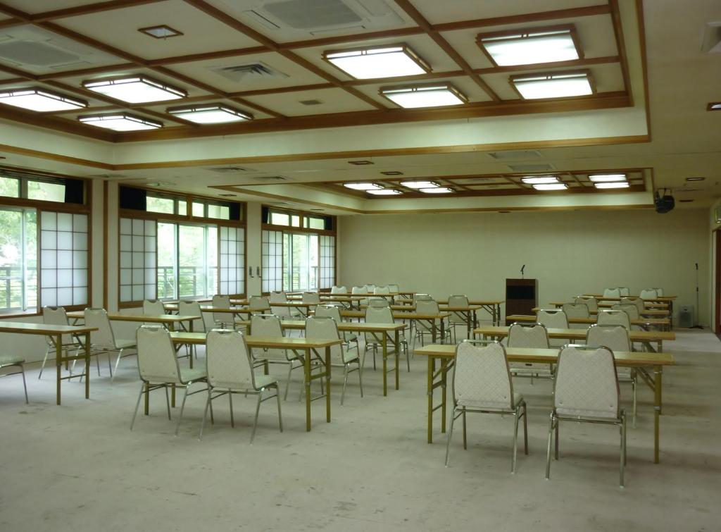 une pièce vide avec des tables, des chaises et des fenêtres dans l'établissement Inn Yokotei, à Nagatoro