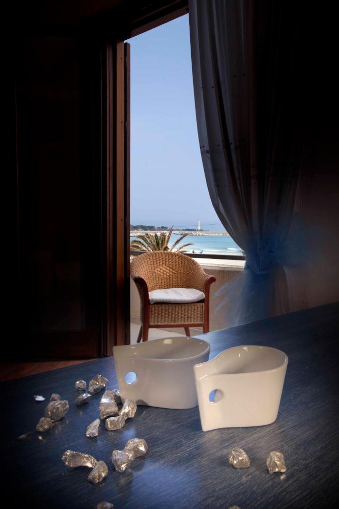 une table avec des coquillages sur une table avec une fenêtre dans l'établissement Mira Spiaggia, à San Vito Lo Capo