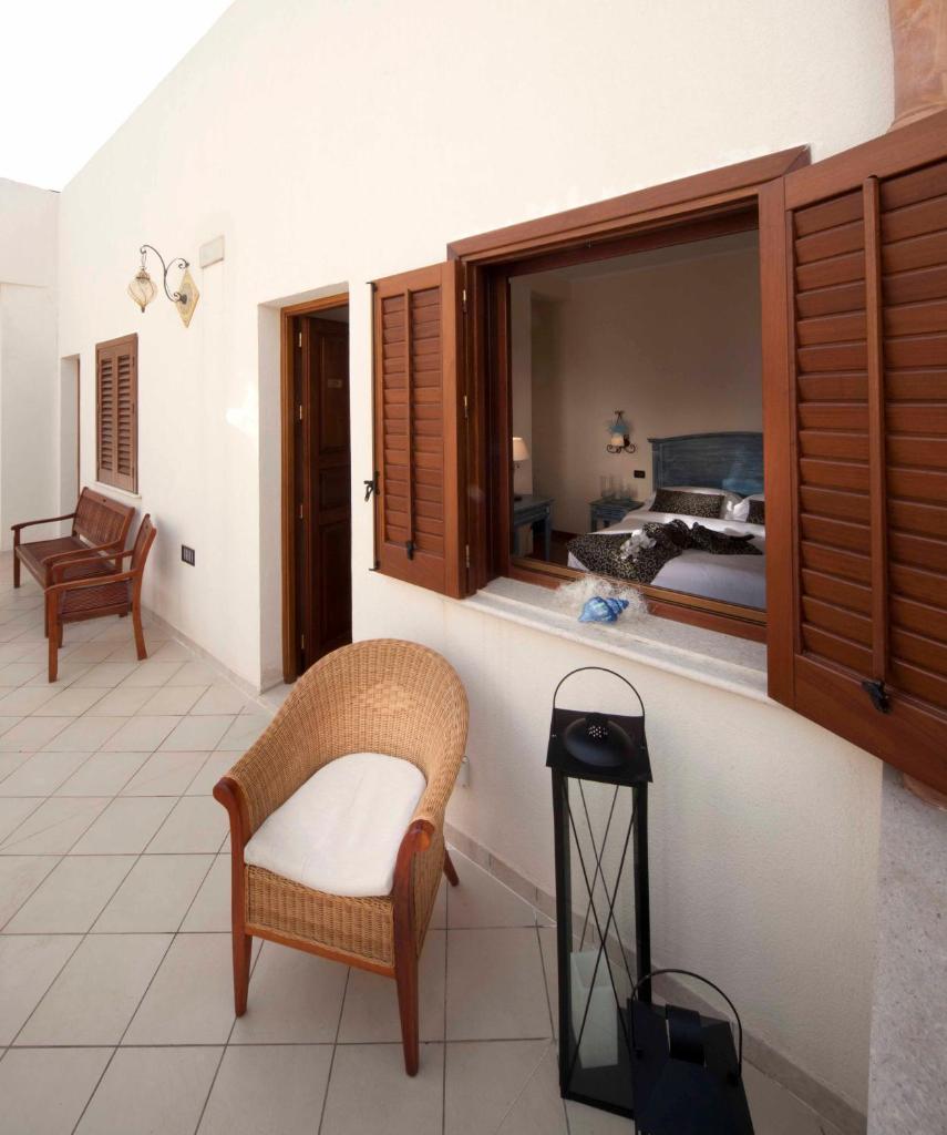 Cette chambre comprend un lit, une chaise et une fenêtre. dans l'établissement Mira Spiaggia, à San Vito Lo Capo