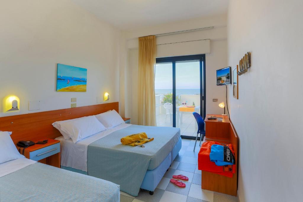 une chambre d'hôtel avec deux lits et un balcon dans l'établissement Residence Sunrise, à San Benedetto del Tronto