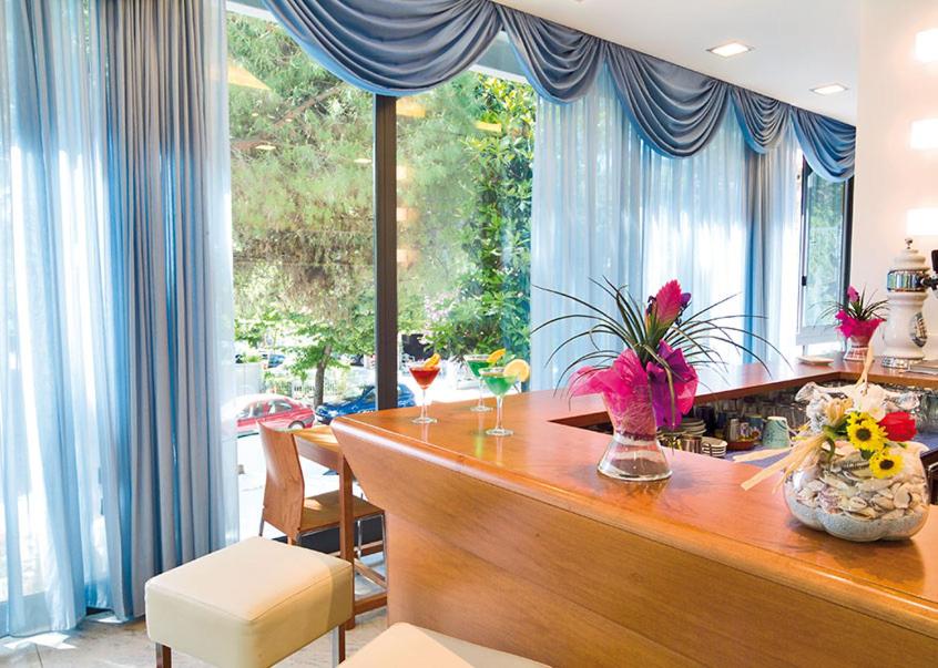 - une cuisine avec un bar fleuri dans l'établissement Renzo Hotel, à Cesenatico