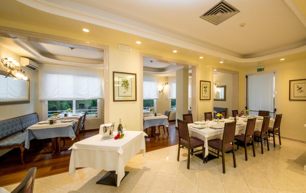 un restaurant avec des tables et des chaises dans une salle dans l'établissement Hotel Helios, à Lido di Jesolo
