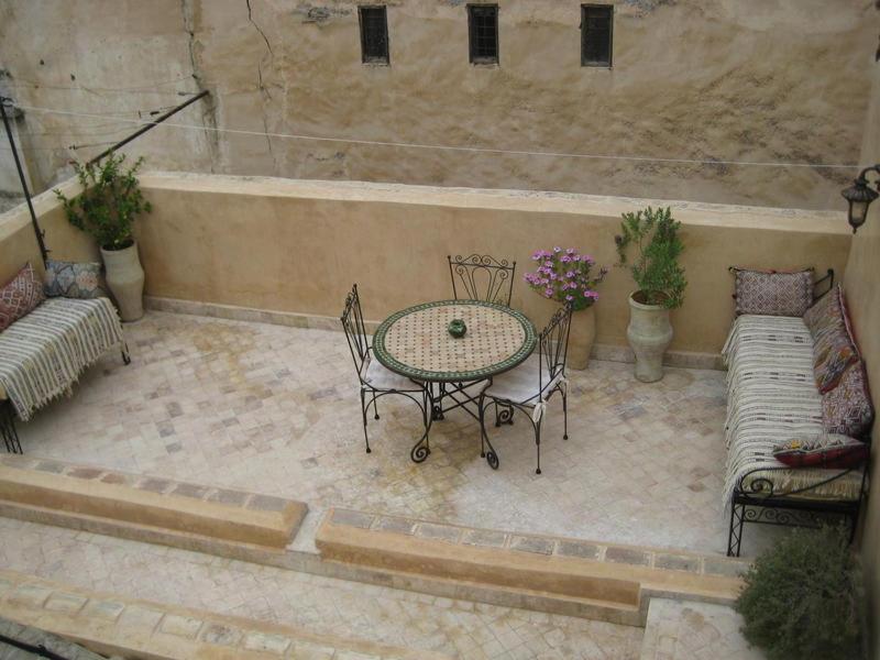 d'une terrasse avec une table, des chaises et une baignoire. dans l'établissement Dar Houdou, à Fès