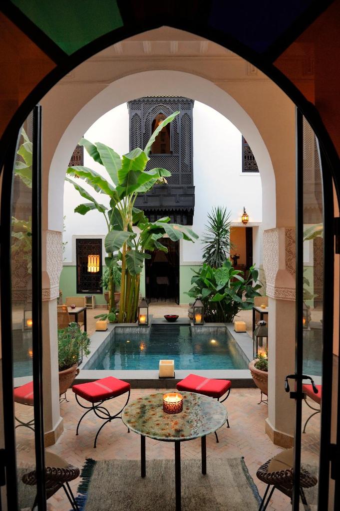 une arche menant à une piscine dans une maison dans l'établissement Riad Azzar, à Marrakech