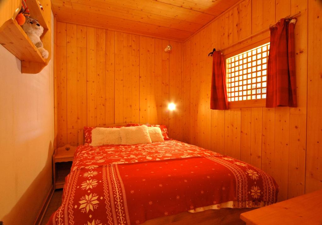 une chambre avec un lit avec une couverture rouge dans l'établissement Apartment Anna, à Courchevel