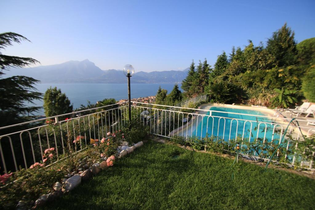 un jardin avec une clôture et une piscine dans l'établissement Villa Margiò, à Torri del Benaco