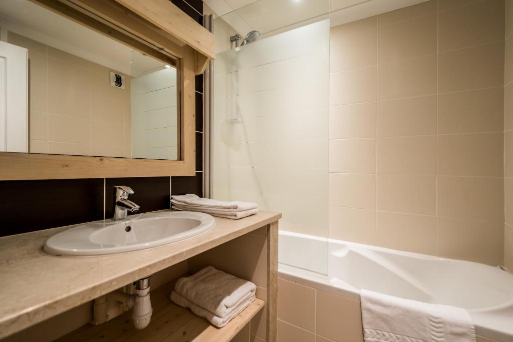 une salle de bain avec un lavabo et une baignoire dans l'établissement Résidence Le Portillo, à Val Thorens 25 autres photos