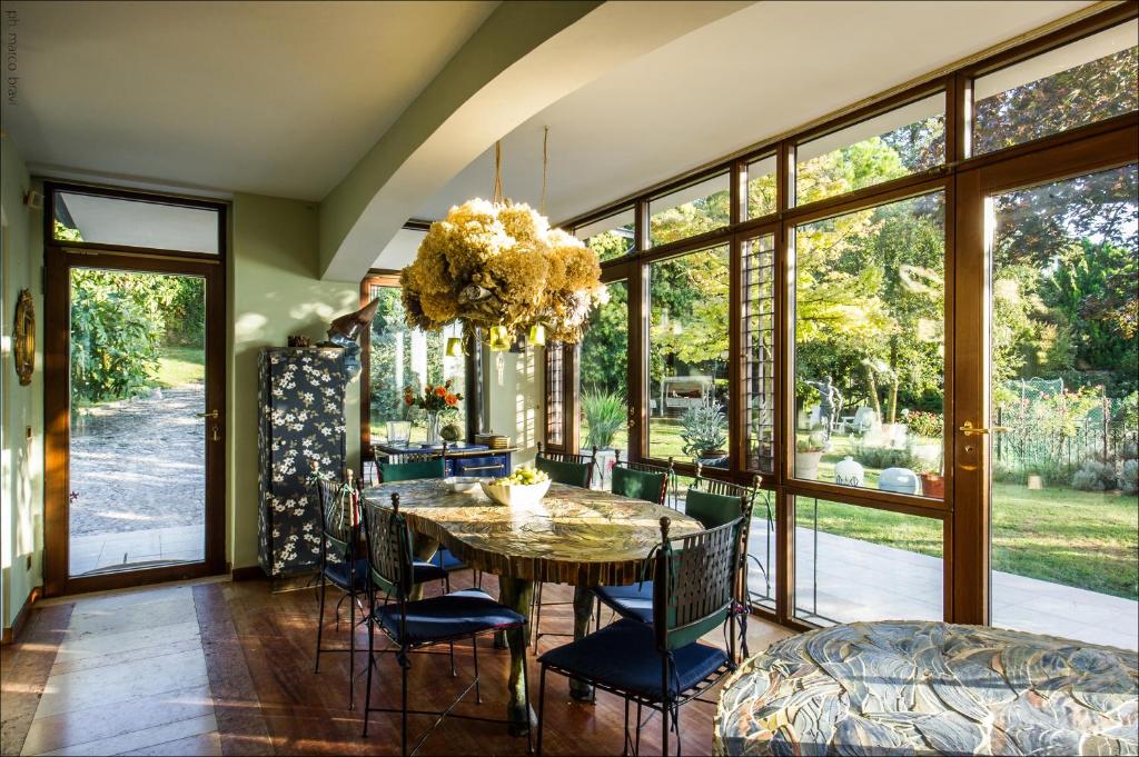une salle à manger avec une table et des chaises dans l'établissement Villa Isidoro ampio parco ,piscina privata, arte e giochi , fitness, à Vérone