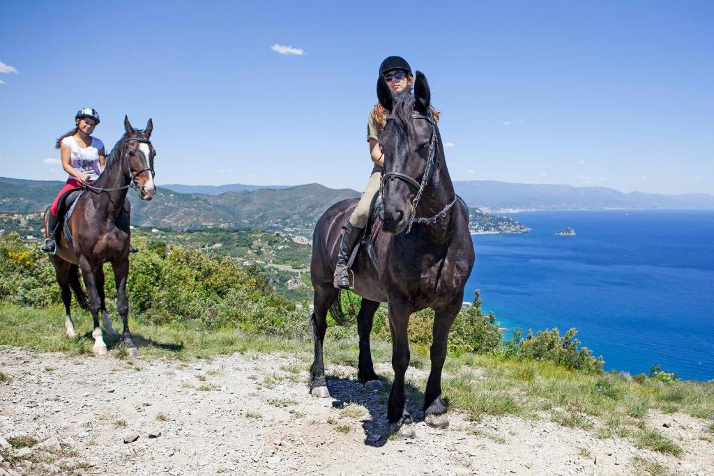 2 personnes à cheval sur une colline près de l'océan dans l'établissement Il Villaggio Di Giuele, à Finale Ligure