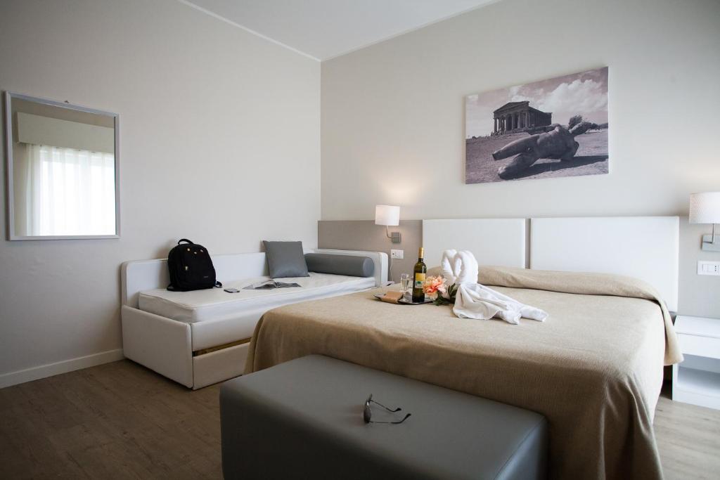 une chambre d'hôtel avec deux lits et un canapé dans l'établissement Hotel Costazzurra Museum & Spa, à San Leone