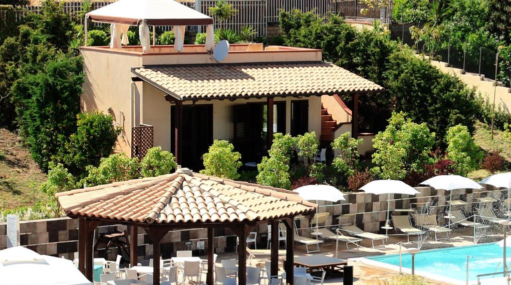 un complexe avec une piscine et un bâtiment dans l'établissement Hotel Costazzurra Museum & Spa, à San Leone