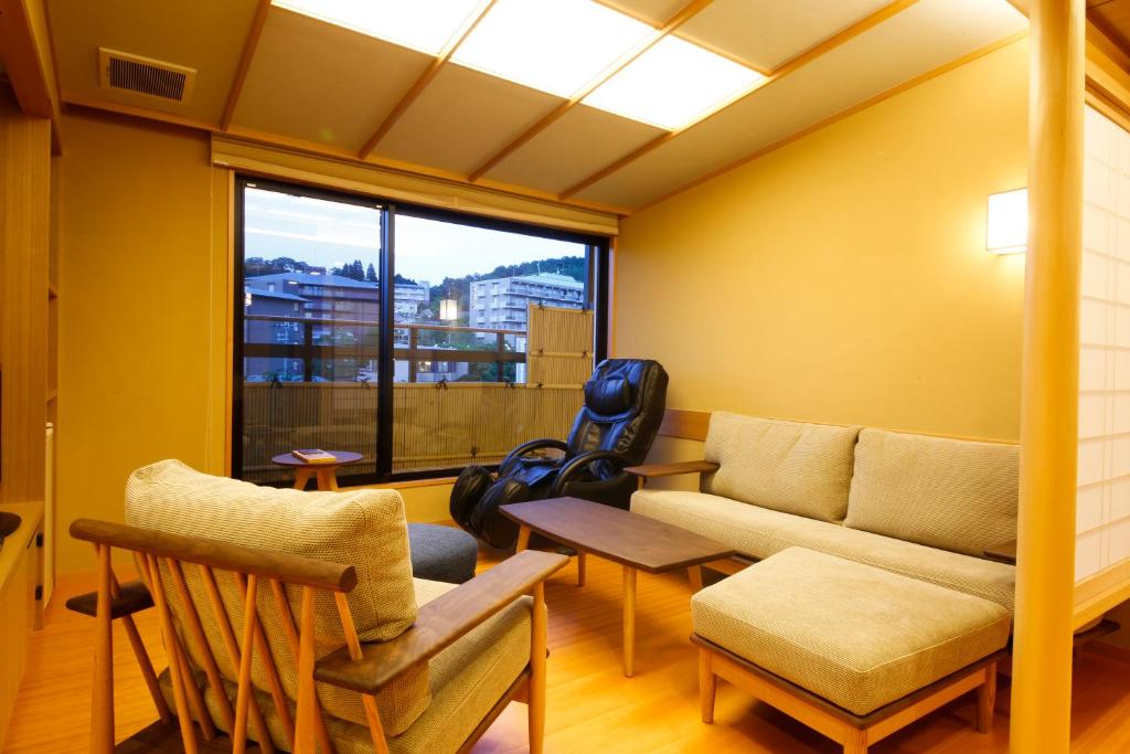un salon avec un canapé, des chaises et une fenêtre dans l'établissement Arima Hot Spring Ryokan Hanamusubi, à Kobe 37 autres photos