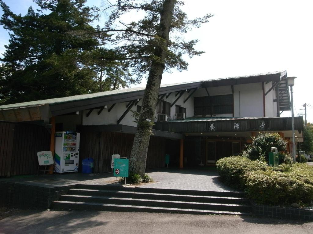 un bâtiment avec un arbre devant lui dans l'établissement Inn Yokotei, à Nagatoro
