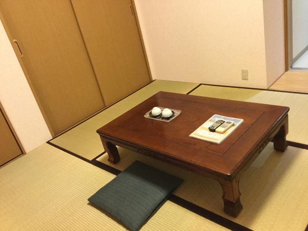 - une petite table avec deux bougies dans la chambre dans l'établissement シーパの湯 Seapa no Yu, à Matsuyama