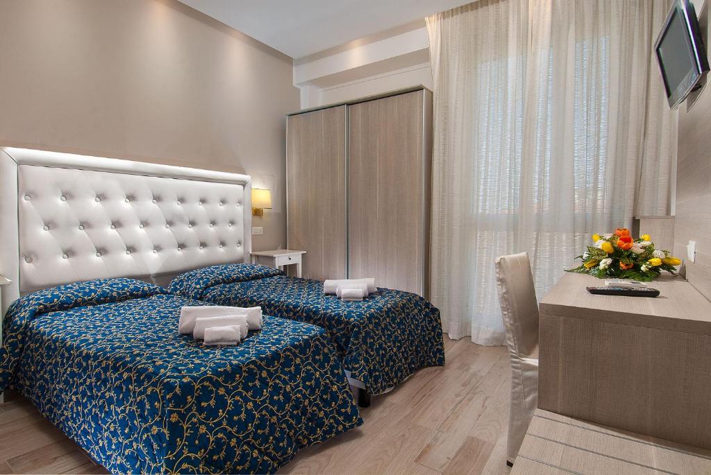 une chambre avec un lit avec une couette bleue dans l'établissement Hotel Mediterraneo, à Pesaro