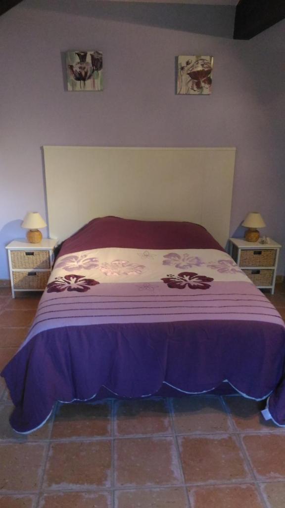 - une chambre avec un lit recouvert d'une couverture violette dans l'établissement Gite Les Oliviers, à Cotignac