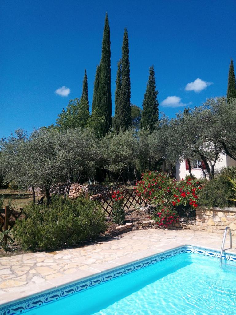 une piscine en face d'un jardin arboré dans l'établissement Gite Les Oliviers, à Cotignac 7 autres photos