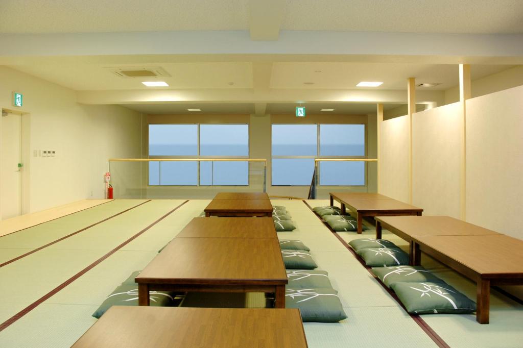 une chambre de classe avec des tables, des bancs et des fenêtres dans l'établissement シーパの湯 Seapa no Yu, à Matsuyama 36 autres photos