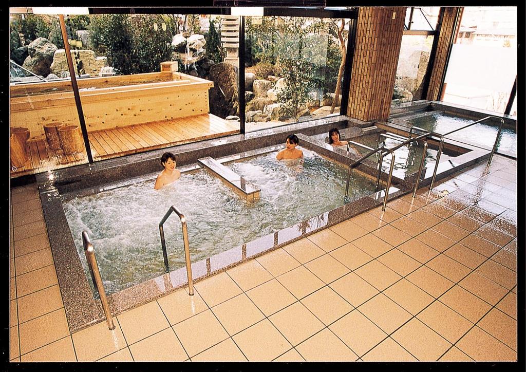 3 hommes dans une piscine d'un hôtel dans l'établissement Yuttarino-Sato Inaka, à Achi