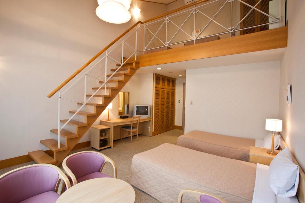 - une chambre avec 2 lits et un escalier dans l'établissement Shiki Resort Aisonet Kusatsu, à Kusatsu
