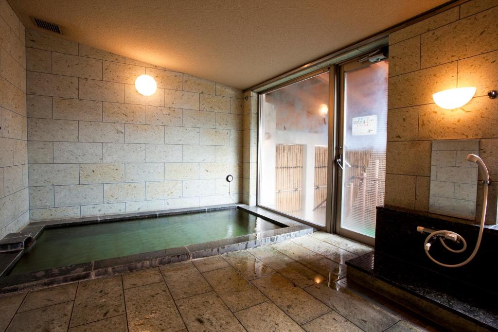 - une piscine dans une chambre avec fenêtre dans l'établissement Shiki Resort Aisonet Kusatsu, à Kusatsu