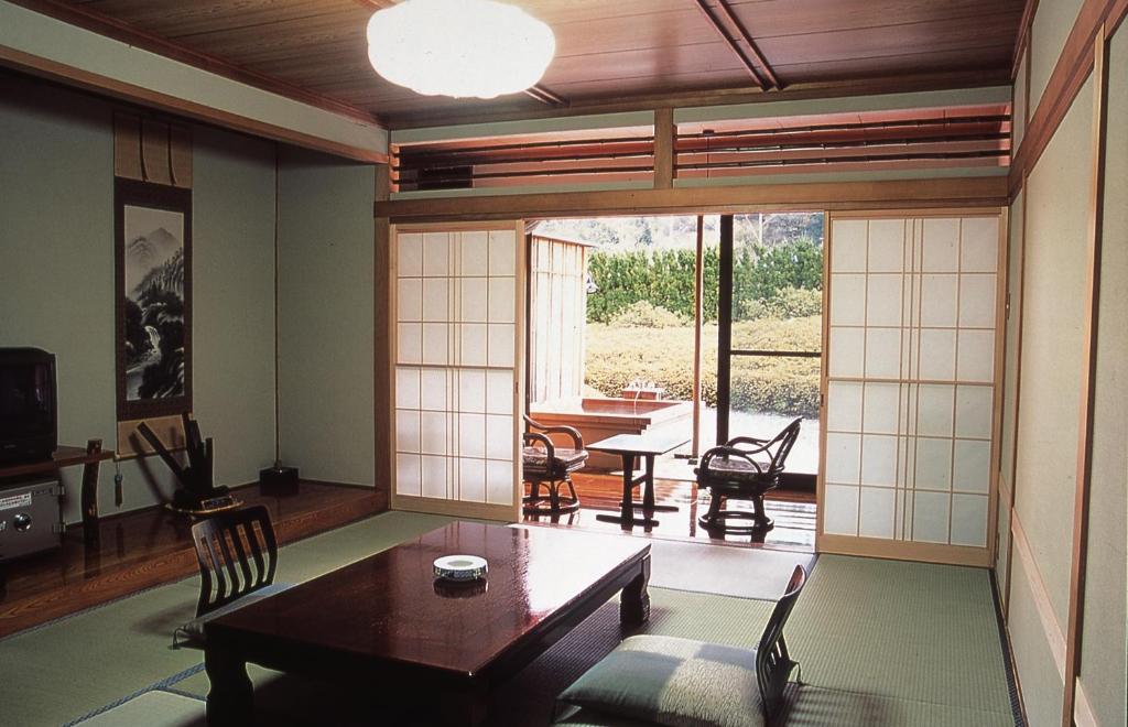 un salon avec une table et des chaises et une fenêtre dans l'établissement Oyado Sansui, à Achi