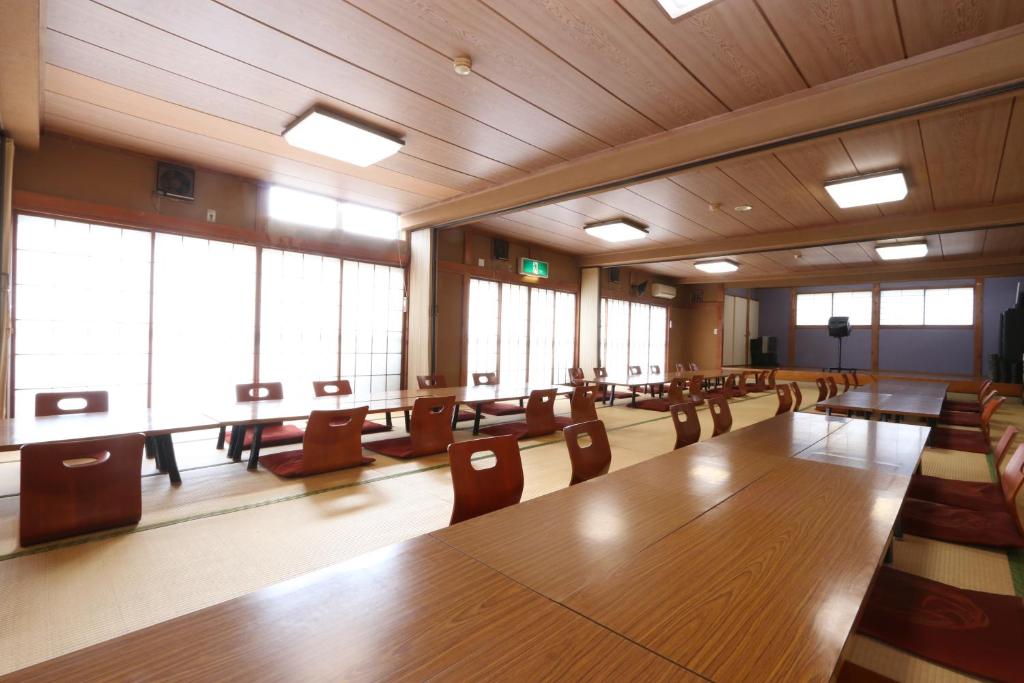 une grande salle de conférence avec une grande table et des chaises en bois dans l'établissement Fujimien, à Fujikawaguchiko 37 autres photos