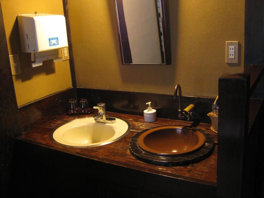 un comptoir de salle de bain avec un lavabo et un miroir dans l'établissement Yumoto Choza, à Takayama