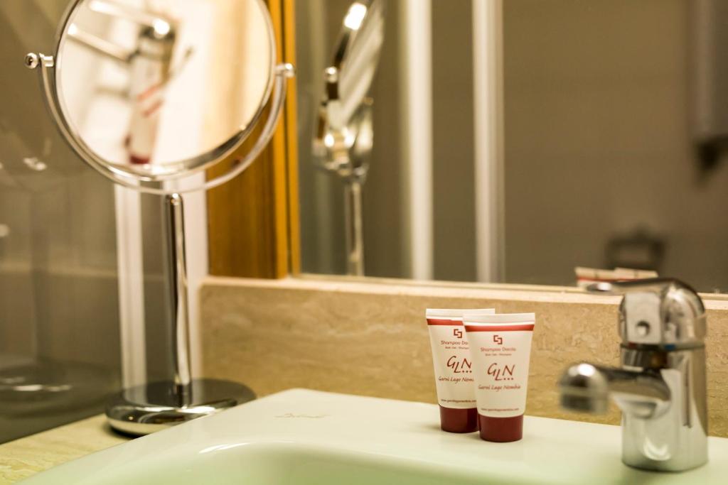 une paire de tasses assises sur un lavabo de salle de bains dans l'établissement Garni Lago Nembia, à San Lorenzo in Banale 41 autres photos