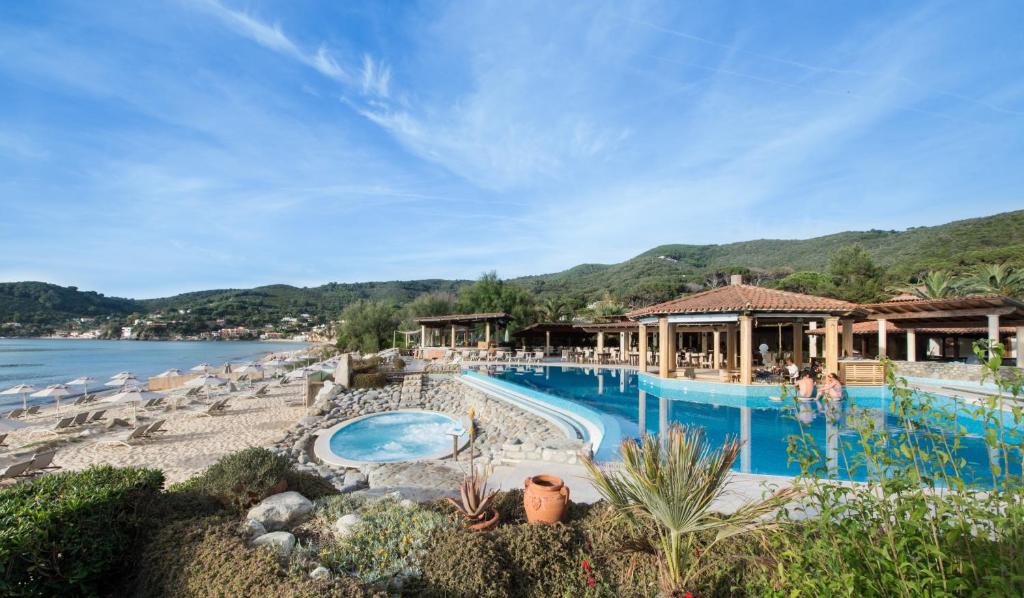 un complexe avec une piscine, des chaises et de l'eau dans l'établissement Hotel Hermitage, à Portoferraio