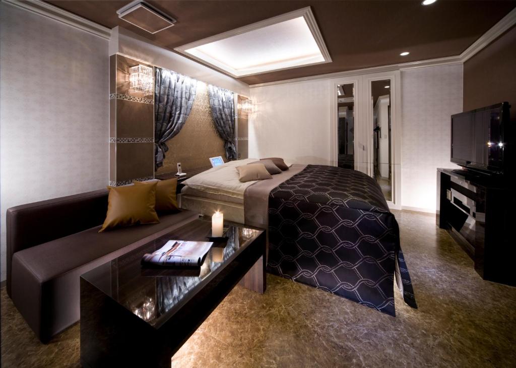 une chambre avec un lit et un canapé dans l'établissement JEWEL HOTEL LUXURY MODERN (Adult Only), à Miyoshi