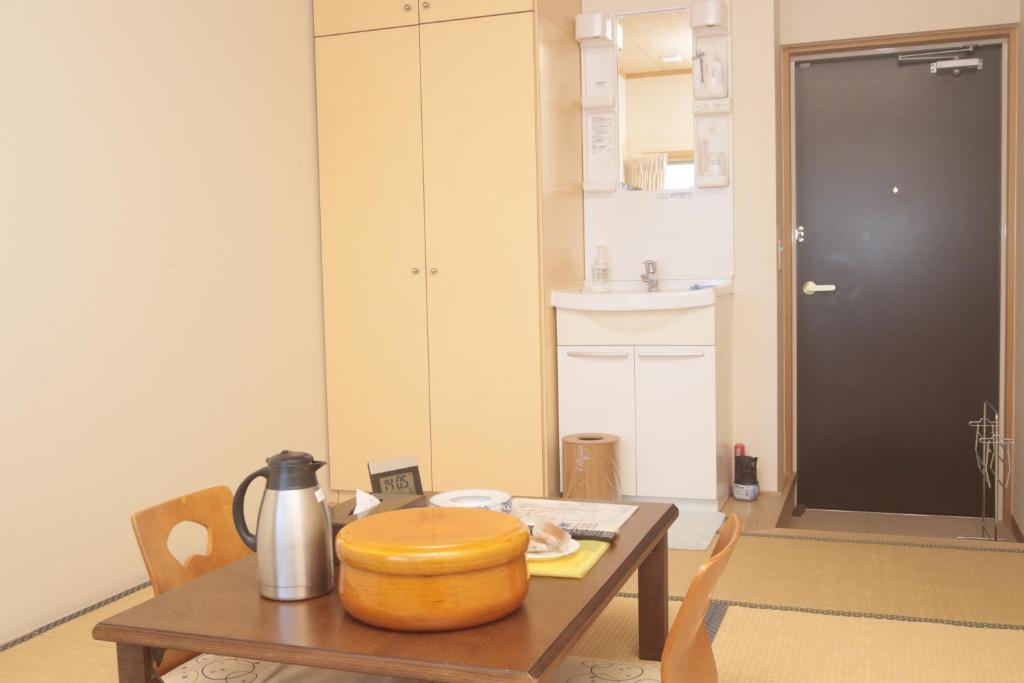 - une cuisine avec une table et une bouilloire dans l'établissement Ikijimaso, à Iki