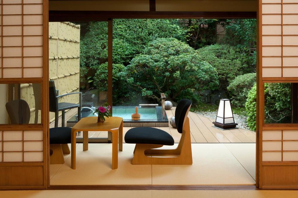 - un salon avec une table et des chaises sur une terrasse dans l'établissement Ito Ryokuyu, à Itō