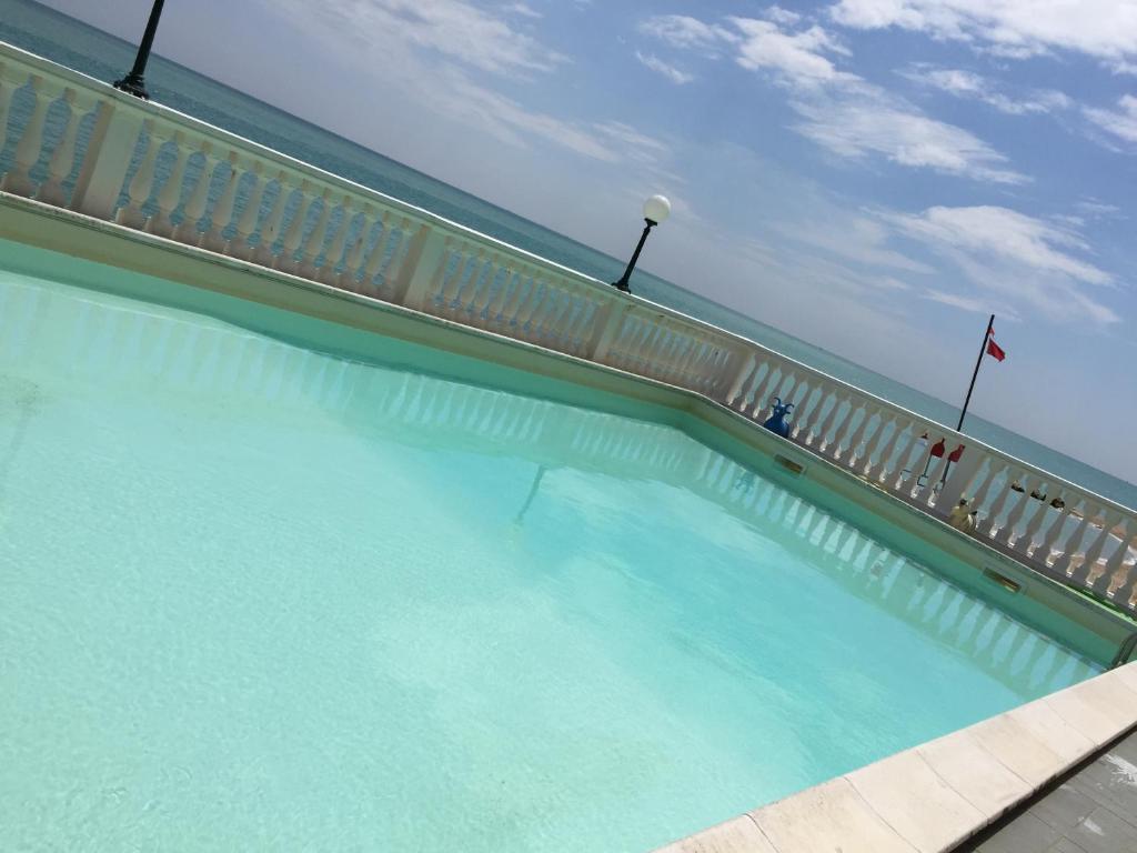 une piscine avec une clôture et de l'eau bleue dans l'établissement Hotel Brigantino Non Dista, à Porto Recanati