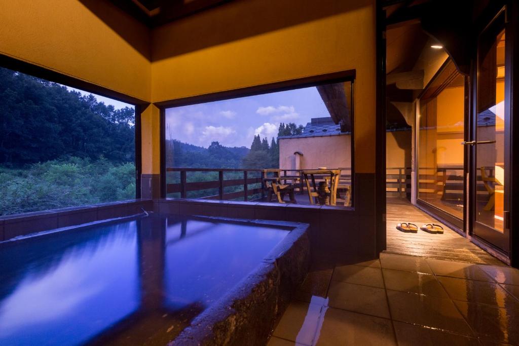 - une piscine dans une maison avec vue sur les montagnes dans l'établissement Satonoyu Waraku 13 years or older, à Minamioguni