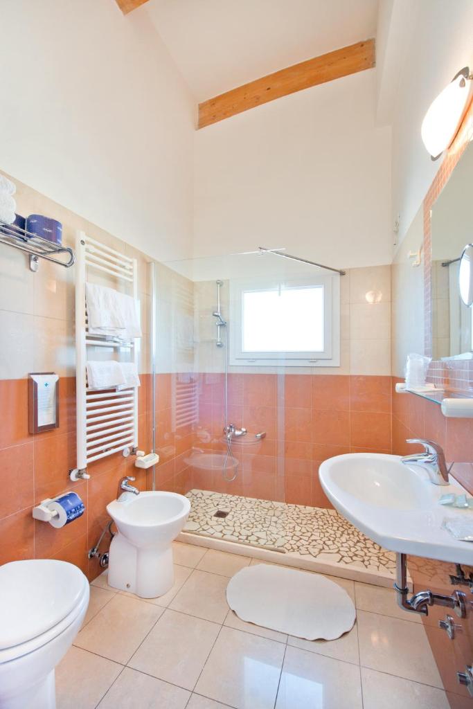 une salle de bain avec toilettes, lavabo et douche dans l'établissement Hotel Sogno, à Cesenatico