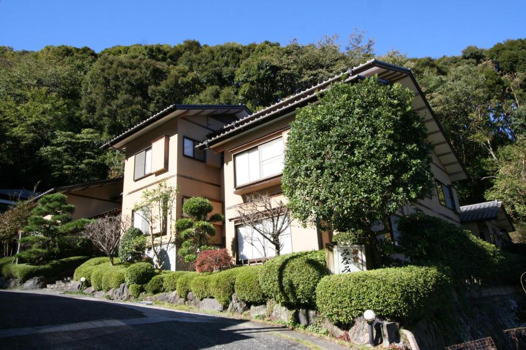 une maison avec des buissons devant elle dans l'établissement Hoshi Meguri, à Shimoda