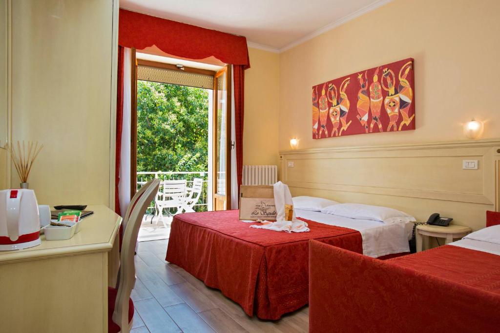 une chambre d'hôtel avec deux lits et une fenêtre dans l'établissement Hotel lo Squalo, à Grottammare