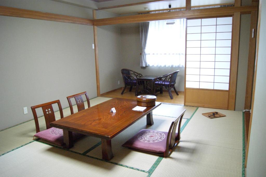 une salle à manger avec une table et des chaises en bois dans l'établissement Wakamizusou, à Fujikawaguchiko 35 autres photos