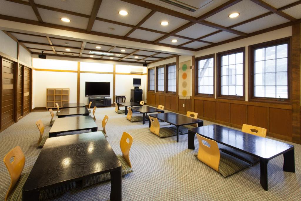 d'une salle de conférence avec des tables et des chaises et une télévision à écran plat. dans l'établissement Schole Hakuba, à Hakuba 37 autres photos